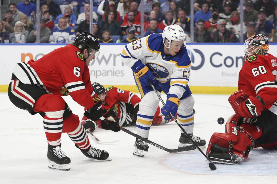 Chicago Blackhawks goaltender Collin Delia (60) blocks a shot by Buffalo Sabres left wing Jeff Skinner (53) while defenseman Jake McCabe (6) tries to get the puck during the second period of an NHL hockey game Friday, April 29, 2022, in Buffalo, N.Y. (AP Photo/Joshua Bessex)