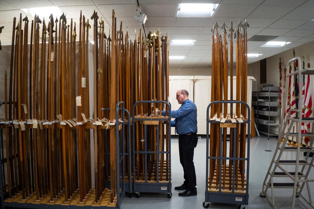 Save the Flags director Matthew J. VanAcker looks through a collection of flagstaffs used for battle flags during the Civil War, part of the Michigan Capitol Battle Flag Collection inside the Michigan Historical Center in Lansing on Tuesday, Feb. 27, 2024.