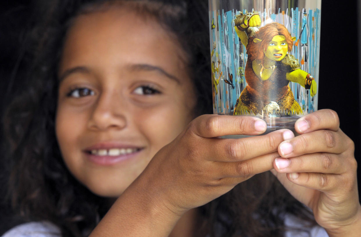 Jasmine Matta, 7, holds up a Shrek-themed glass distributed in McDonald's Happy Meals featuring her favorite character, Fiona, at home on Friday, June 4, 2010, in West Hollywood, Calif.  (AP Photo/Adam Lau)