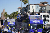 Buses carrying Los Angeles Rams players and coaches drive past fans during the team's victory parade in Los Angeles, Wednesday, Feb. 16, 2022, following their win Sunday over the Cincinnati Bengals in the NFL Super Bowl 56 football game. (AP Photo/Marcio Jose Sanchez)