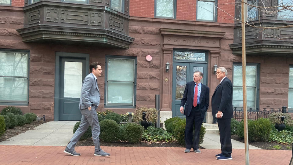 Matt Gaetz, Paul Gosar and Ralph Norman face one another on a brick sidewalk in front of a building.