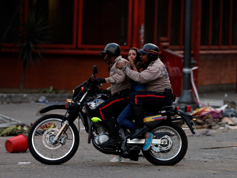 Bolivarian National Police detain an anti-government demonstrator during clashes in Caracas, Venezuela, Thursday, March 6, 2014. A National Guardsman and a civilian were killed Thursday in a clash between residents of a Caracas neighborhood and armed men who tried to remove a barricade, Venezuelan officials said. (AP Photo/Fernando Llano)