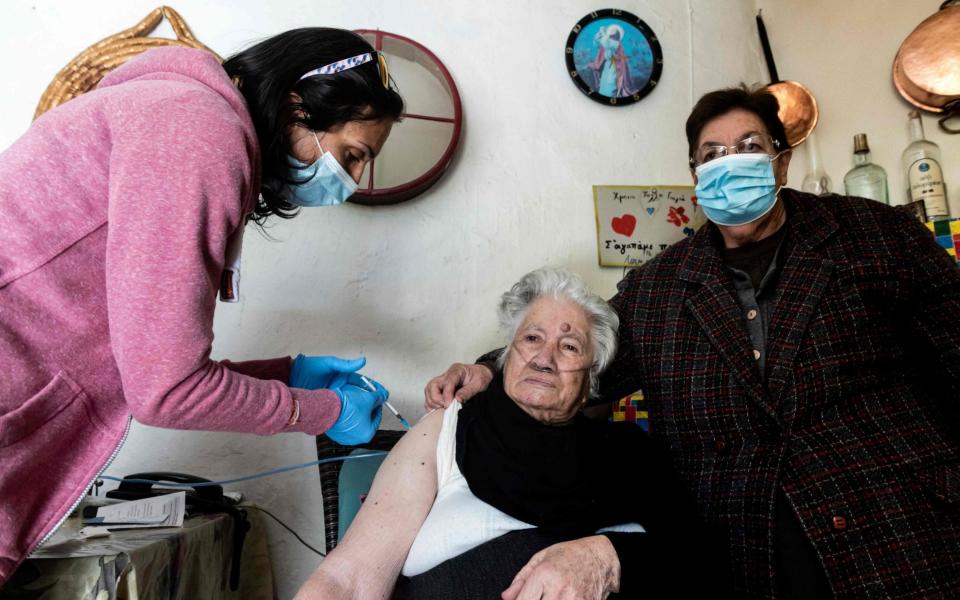 An 87-year-old Cypriot woman receives a vaccine against the coronavirus in the village of Louvaras in the Limassol district -  IAKOVOS HATZISTAVROU / AFP