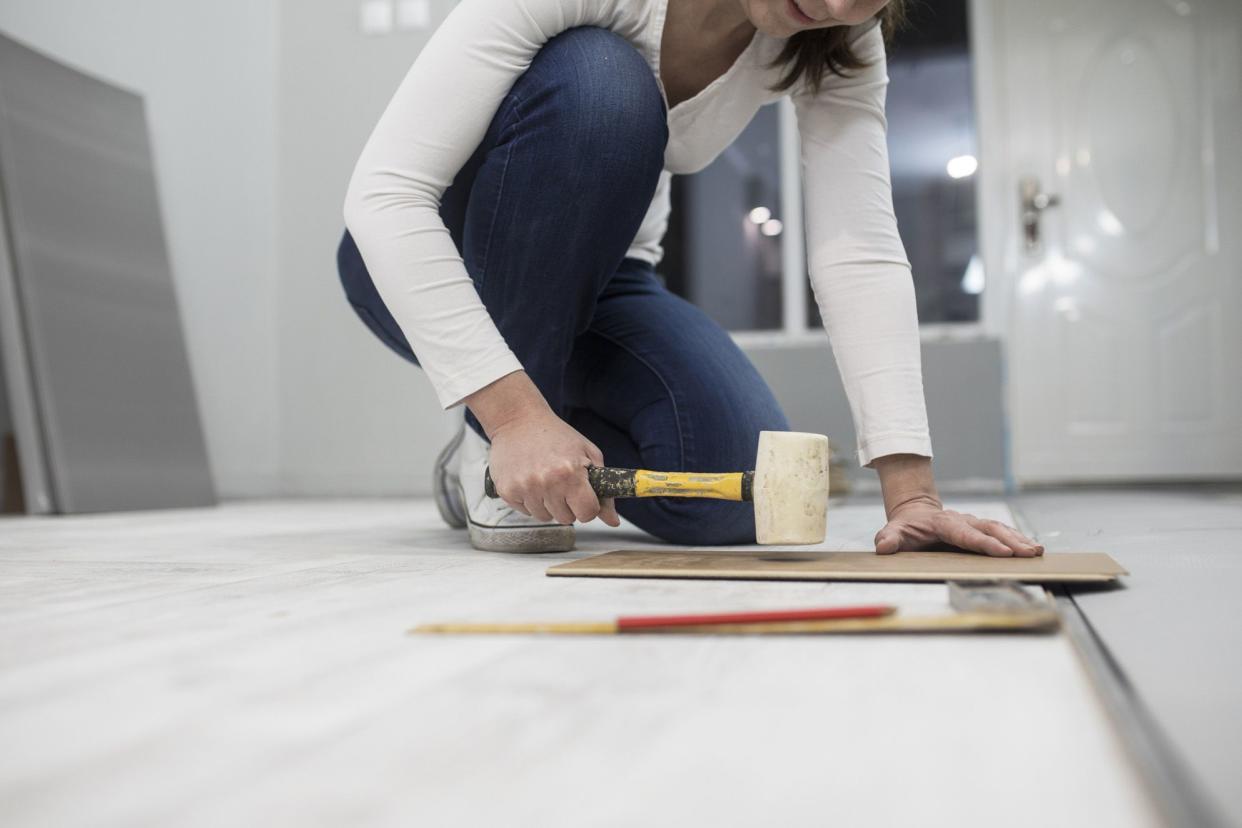 woman installing a wooden floor