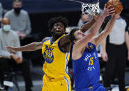 Denver Nuggets center Nikola Jokic, front, drives to the rim for a reverse dunk basket past Golden State Warriors center James Wiseman in the first half of an NBA basketball game Thursday, Jan. 14, 2021, in Denver. (AP Photo/David Zalubowski)