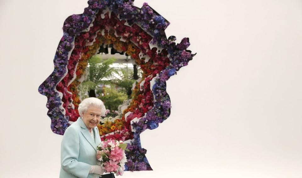 <p>The queen held a pink bouquet while she stood in front of a floral exhibit by the New Covent Garden Flower Market in London. </p>