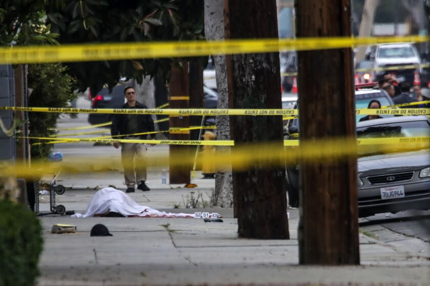 El Monte, CA - June 15: Crime scene investigators and detectives investigate near the body of a suspect on the sidewalk after a shooting on Tuesday night that left two El Monte police officers dead at Siesta Inn Motel on Wednesday, June 15, 2022 in El Monte, CA. (Irfan Khan / Los Angeles Times)