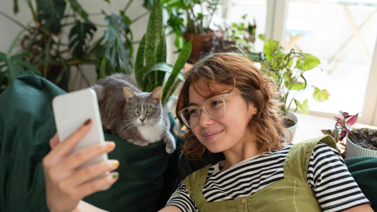 woman taking a picture of a cat