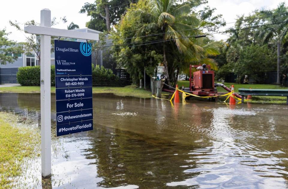 Un letrero de venta sobresale de una calle inundada cerca de una bomba temporal en el Little River Pocket Park, el lunes 30 de octubre de 2023, en Miami, Florida. El lunes fue la marea real más alta del año para el sur de la Florida, inundando calles, accesos vehiculares de casas y parques.