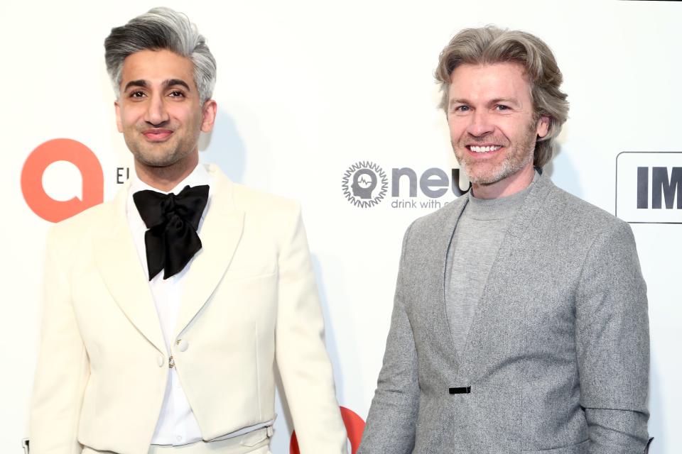 tan france and his husband rob france pose on a red carpet