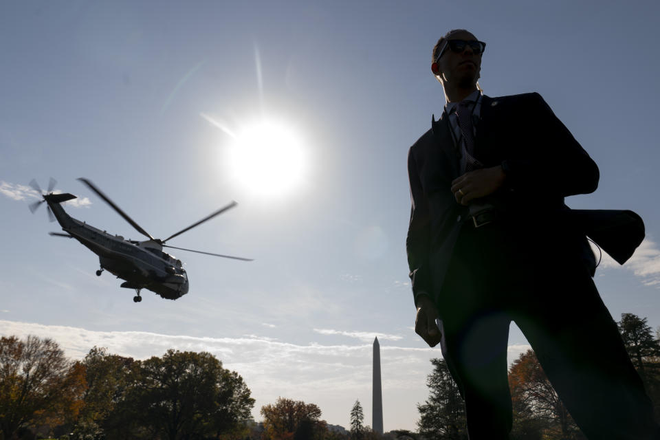 The Washington Monument is visible as a member of the Secret Service stands guard in front of Marine One with President Joe Biden abroad as it lifts off from the South Lawn of the White House in Washington, Thursday, Nov. 9, 2023, for a short trip to Andrews Air Force Base, Md., and then on to Illinois. (AP Photo/Andrew Harnik)