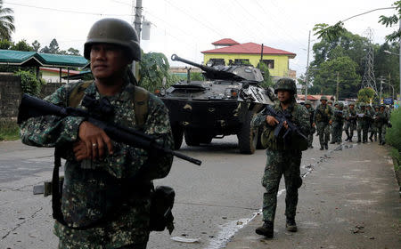 Philippine Marines walk next to an armoured fighting vehicle (AFV) as they advance their positions in Marawi City, Philippines May 28, 2017. REUTERS/Erik De Castro