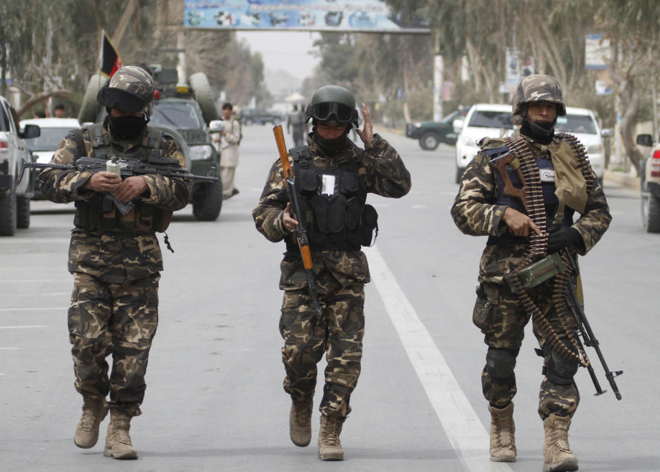 CAPTION CORRECTION, CORRECTS PHOTOGRAPHER'S NAME IN SIGNOFF - Afghan National Intelligent officers take up position after an attack by a suicide squad on the former Afghan intelligence headquarters in the center of Kandahar, Afghanistan, Wednesday, March 12, 2014. Afghan police officials said three insurgents tried to storm the former intelligence service headquarters in the southern city of Kandahar, prompting a fierce gunbattle with security forces that left the attackers dead. (AP Photo/Allauddin Khan)