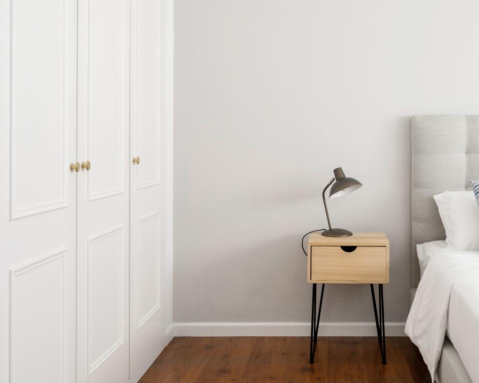 Neutral bedding white cupboards with cupboard, bed and beside cabinet