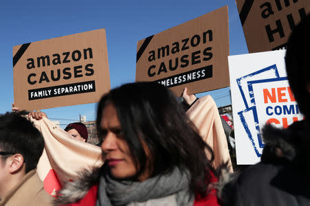 Demonstrators hold signs during a protest against Amazon in the Long Island City section of the Queens borough of New York, U.S., February 14, 2019. REUTERS/Shannon Stapleton