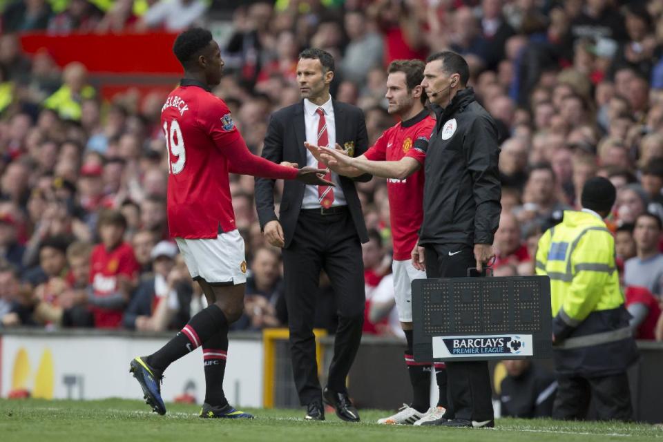 Manchester United's Danny Welbeck, left, is substituted for teammate Juan Mata as interim manager Ryan Giggs, centre, watches proceedings on the pitch during their English Premier League soccer match against Norwich City at Old Trafford Stadium, Manchester, England, Saturday April 26, 2014. (AP Photo/Jon Super)