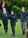 <p>Meghan throws the gumboot during the contest as Prince Harry looks on. </p>