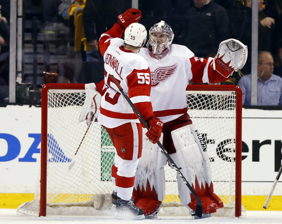 Detroit Red Wings goalie Jimmy Howard celebrates with teammate Niklas Kronwall (55) after the Red Wings defeated the Boston Bruins 1-0 in Game 1 of a first-round NHL playoff series, in Boston on Friday, April 18, 2014. (AP Photo/Winslow Townson)