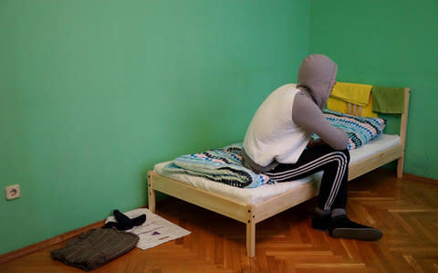A gay man who fled Chechnya sits on his bed in Moscow in April. - Credit: Naira Davlashyan/AFP/Getty Images