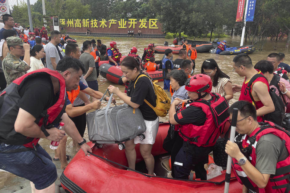 Residents are evacuated by rubber boats through flood waters in Zhuozhou in northern China's Hebei province, south of Beijing, Wednesday, Aug. 2, 2023. China's capital has recorded its heaviest rainfall in at least 140 years over the past few days. Among the hardest hit areas is Zhuozhou, a small city that borders Beijing's southwest. (AP Photo/Andy Wong)