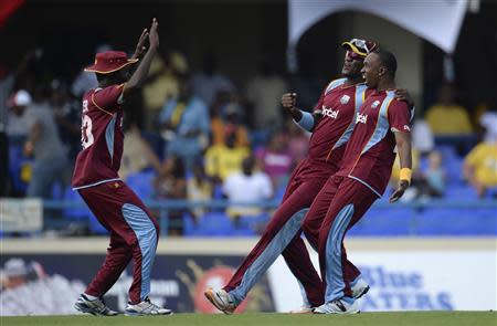 West Indies' Nikita Miller (L) celebrates with teammates Darren Sammy and Dwayne Bravo (R) after the dismissal of England's Jos Buttler during the second one-day international cricket match at North Sound, Antigua March 2, 2014. REUTERS/Philip Brown