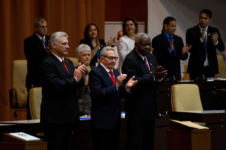 Cuban President Miguel Diaz-Canel (L), Cuban Communist Party leader Raul Castro (C) and National Assembly President Esteban Lazo applaud during the enactment of the new constitution, in Havana, Cuba April 10, 2019. Irene Perez/Courtesy Cubadebate/Handout via REUTERS