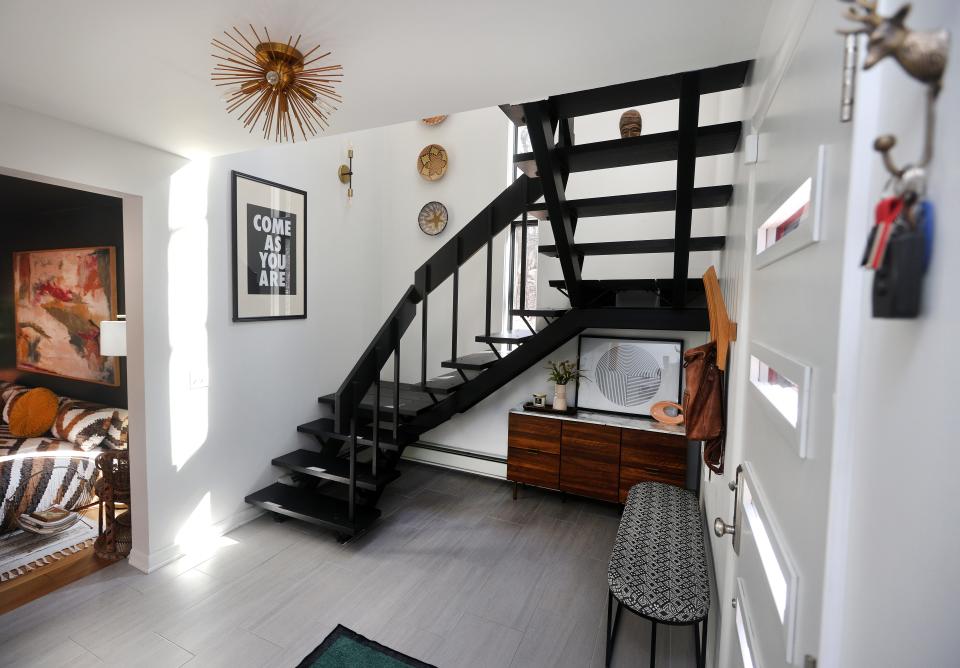 The front foyer offers an entrance into one of the sitting rooms and an open staircase to the upper level.