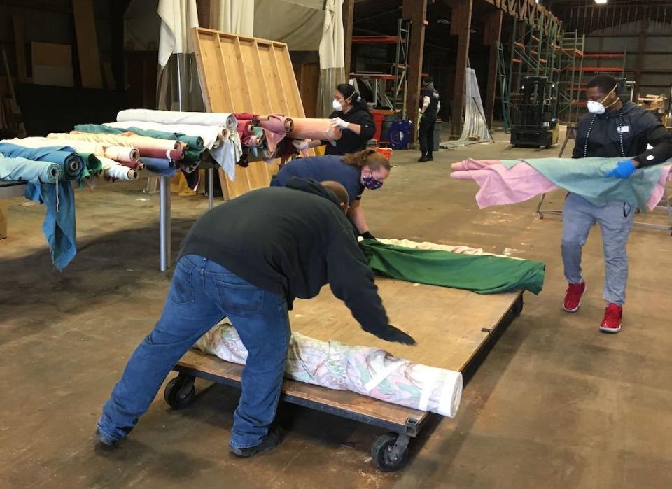 Volunteers sort through 4,000 yards of donated fabric destined for mask-making kits.