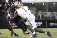 Central Florida running back RJ Harvey, left, is tackled by Georgia Tech linebacker Charlie Thomas (1) after rushing for yardage during the second half of an NCAA college football game, Saturday, Sept. 24, 2022, in Orlando, Fla. Thomas was penalized for targeting on the play and was disqualified from the game. (AP Photo/Phelan M. Ebenhack)