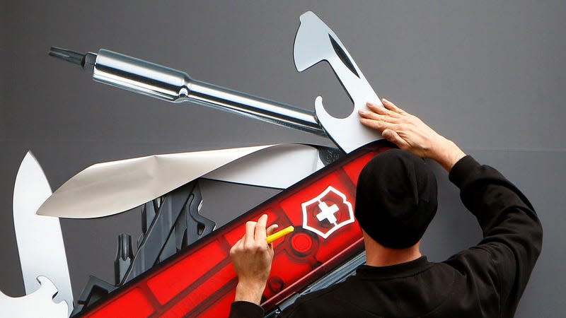A worker sticks a picture of a Swiss army knife on a window of a Victorinox store in Zurich, Switzerland - Photo: Arnd Wiegmann (Reuters)