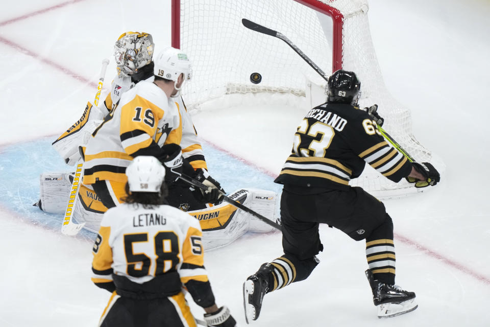 Boston Bruins left wing Brad Marchand (63) scores past Pittsburgh Penguins goaltender Alex Nedeljkovic, back left, and right wing Reilly Smith (19) in the third period of an NHL hockey game, Thursday, Jan. 4, 2024, in Boston. (AP Photo/Steven Senne)