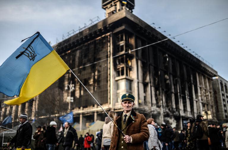 An elderly protester waves a Ukrainian flag on Independence Square in Kiev, on February 26, 2014