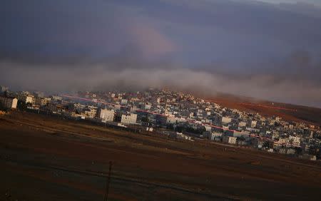 Tracer rounds light the sky over the Syrian town of Kobani during an airstrike, as seen from the Mursitpinar crossing on the Turkish-Syrian border in the southeastern town of Suruc in Sanliurfa province, October 20, 2014. REUTERS/Kai Pfaffenbach