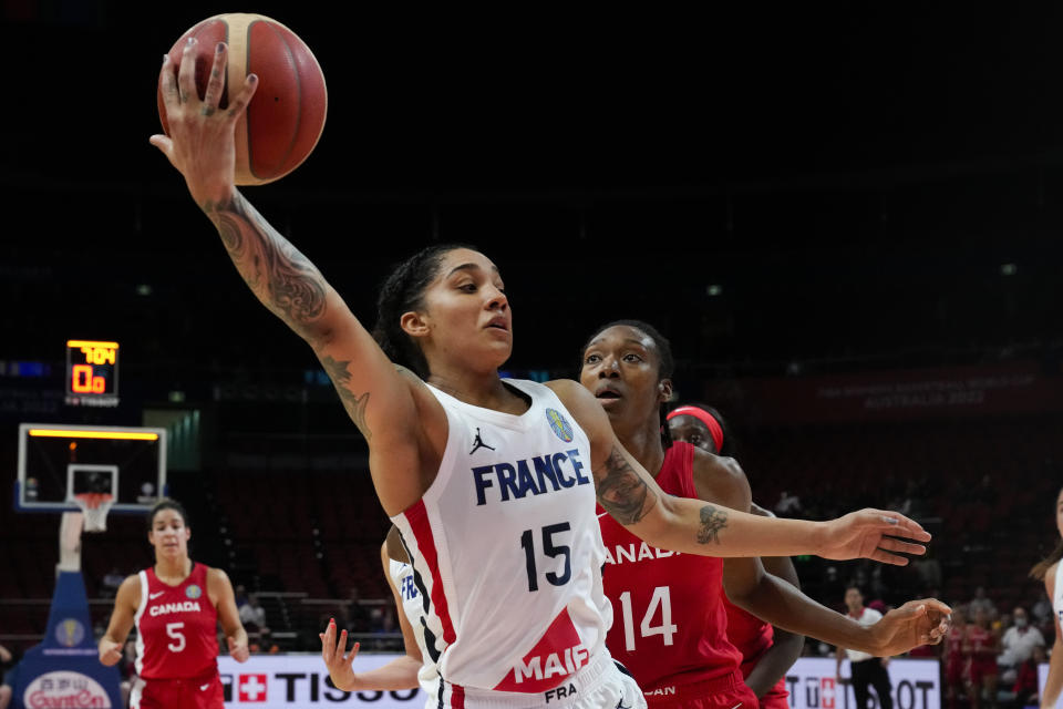 France's Gabby Williams, left, reaches for the ball as Canada's Kayla Alexander watches during their game at the women's Basketball World Cup in Sydney, Australia, Friday, Sept. 23, 2022. (AP Photo/Mark Baker)