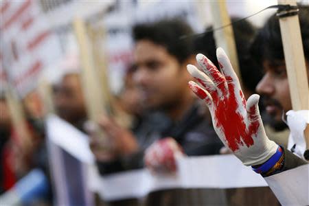 A Tamil demonstrator holds up a hand as they wear a glove covered with fake blood during a protest near the Commonwealth Secretariat in London November 15, 2013. REUTERS/Stefan Wermuth