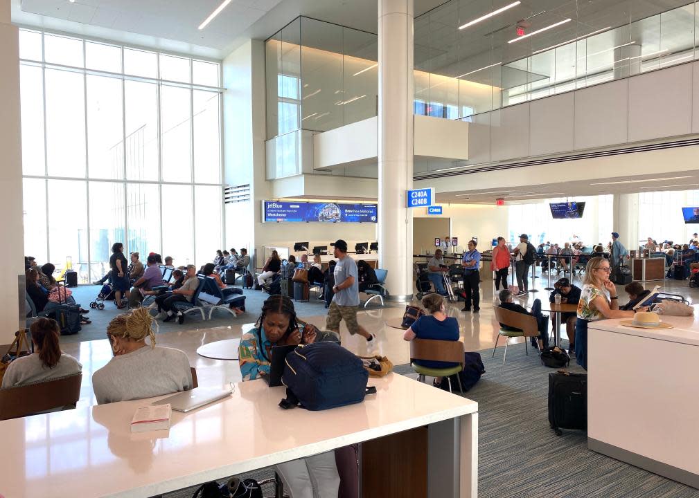 Passengers wait at a gate at Orlando International Airport for a delayed flight.