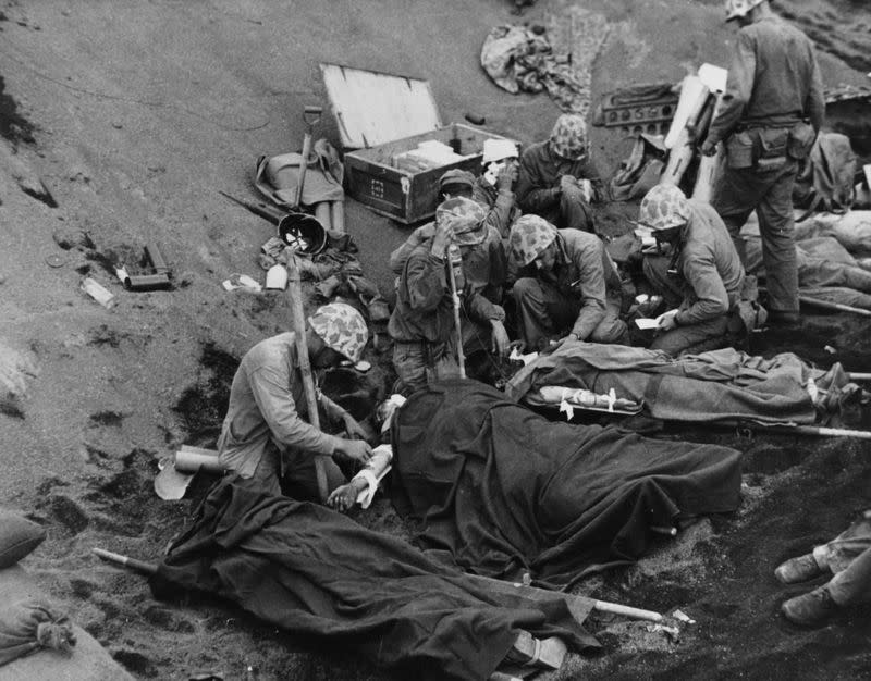 U.S. Navy doctors and corpsmen administer first aid to wounded Marines on Iwo Jima