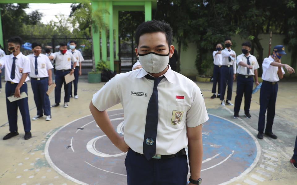 Students wearing face masks as a precaution against the new coronavirus line up at their school during the first day of reopening of state high schools in Bekasi on the outskirts of Jakarta, Indonesia, July 13, 2020. (AP Photo/Achmad Ibrahim)