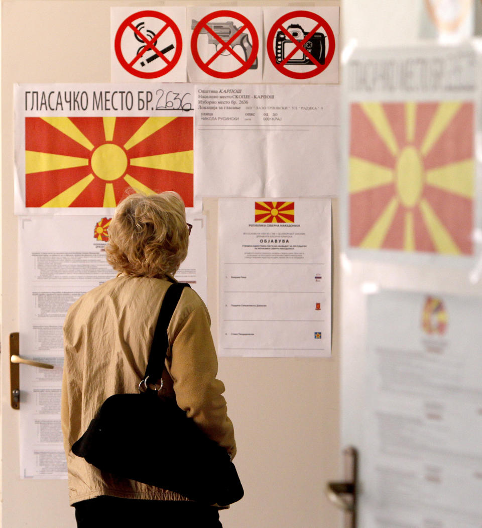 A woman checks lists before voting for the presidential election at a polling station in Skopje, North Macedonia, Sunday, April 21, 2019. Polls were opened early on Sunday in North Macedonia for presidential elections seen as key test of the government following deep polarization after the country changed its name to end a decades-old dispute with neighboring Greece over the use of the term "Macedonia". (AP Photo/Boris Grdanoski)