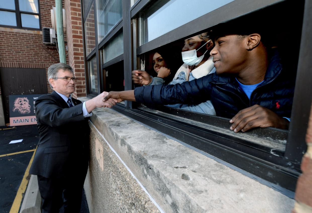 Mayor Jim Langfelder, left, shakes hands with ninth grader Damonicee Palmore, 14, of Springfield. while attending the Lanphier High School groundbreaking. Mayor Langfelder walked over and talked and shook hands with some of the students watching the groundbreaking ceremony from their classroom window Thursday April 14, 2022. [Thomas J. Turney/ The State Register-Journal]