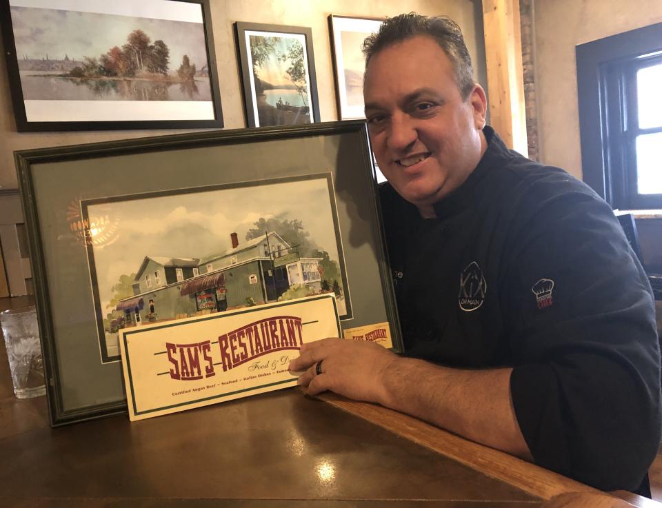 Alexander "Xan" Bacon, co-owner of KiX on Main restaurant in Canandaigua, is marking 35 years in the restaurant business. He's showing off a photo of one of the places where it all started, Sam's on the Corner in Canandaigua.