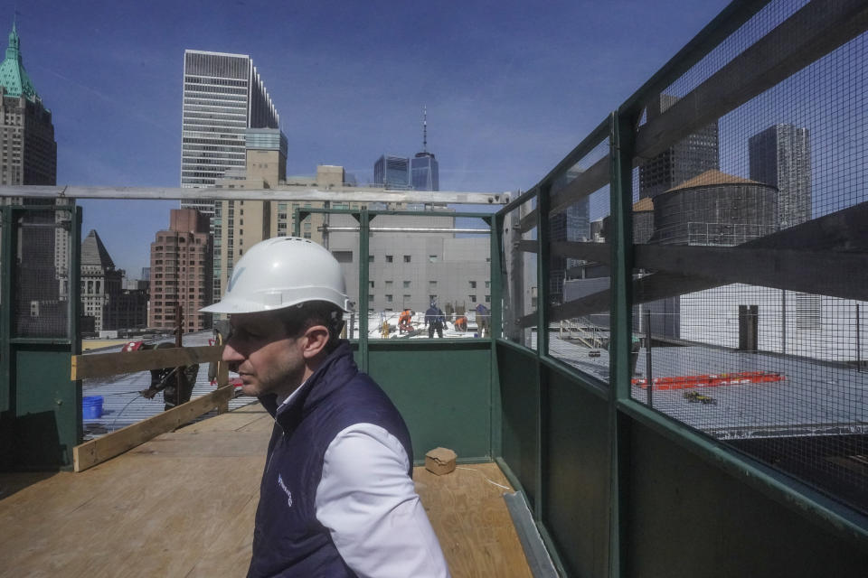 Joey Chilelli, managing director of real estate firm Vanbarton Group, tours rooftop construction at a high rise undergoing conversion to residential apartments in Manhattan's financial district, Tuesday, April 11, 2023, in New York. A growing number of developers are considering converting empty office towers into housing as part of an effort to revive struggling downtown business districts that emptied out during the pandemic. (AP Photo/Bebeto Matthews)