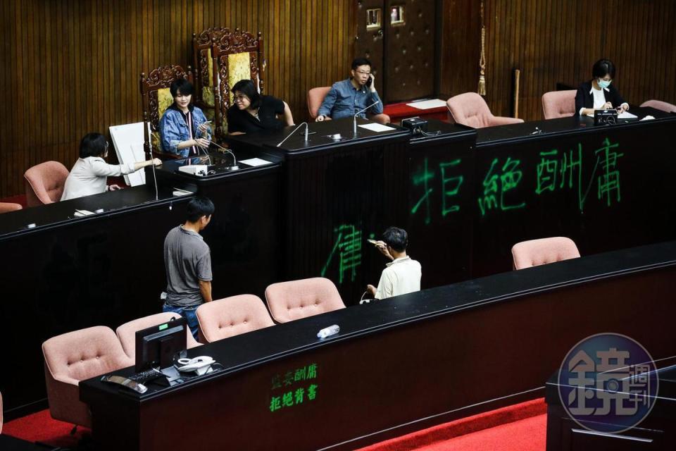 6月29日民進黨立委奪回議場後，工作人員修復議場被噴漆的主席台。