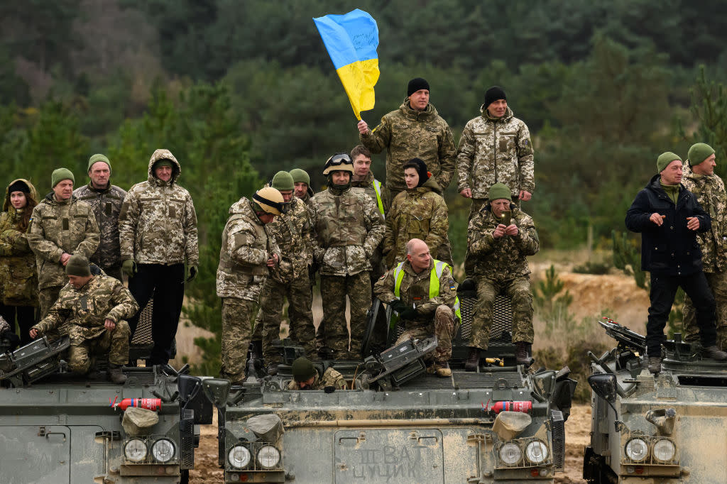 Ukrainian recruits and their British Armed Forces trainers pose for a photograph on Driver Tank Trainer (DTT) armoured vehicles at a military facility, on Feb. 23, 2023 in Southern England.