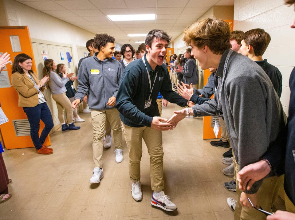 Jackson Price high fives students as Marian basketball players are greeted by students as the walk the halls with the drum line Thursday, March 24, 2022 at Marian High School. The team is headed to the 3A state championship game on Saturday in Indianapolis. 