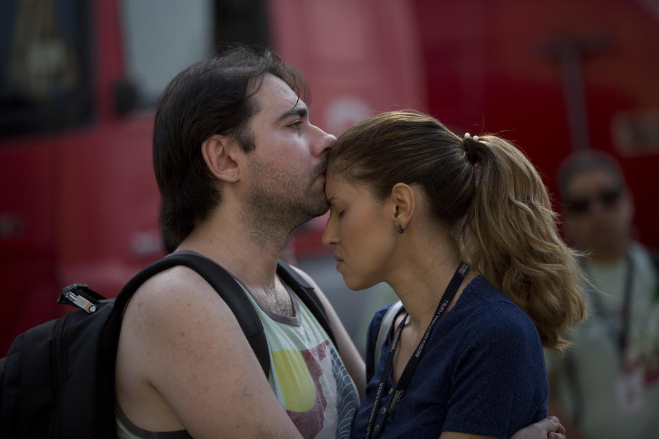 National Museum personnel embrace as they stand outside the burned National Museum in Rio de Janeiro, Brazil, Monday, Sept. 3, 2018. A huge fire engulfed Brazil's 200-year-old museum which houses artifacts from Egypt, Greco-Roman art and some of the first fossils found in Brazil. (AP Photo/Silvia Izquierdo)