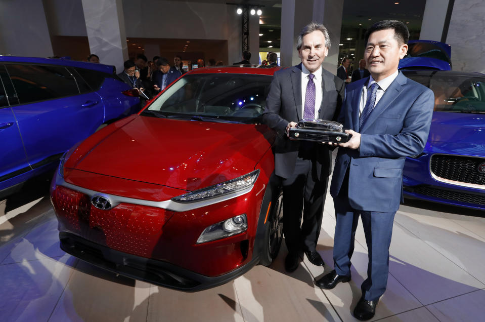 Brian Smith, left, Chief Operating Officer, Hyundai Motor America and Yong-woo William Lee, President and CEO of Hyundai Motor North America hold the North American SUV of the Year trophy next to the Hyundai Kona award during media previews for the North American International Auto Show in Detroit, Monday, Jan. 14, 2019. (AP Photo/Paul Sancya)