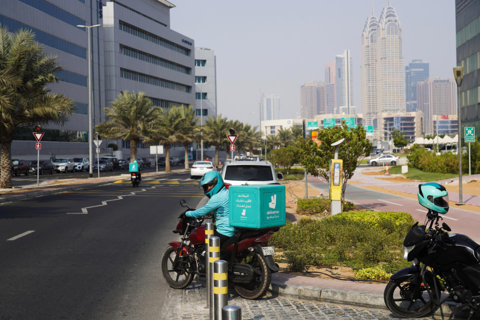 A delivery driver for the app Deliveroo prepares to make a delivery, in Dubai, United Arab Emirates, Thursday, Sept. 9, 2021. Advocates and workers say that casualties among food delivery riders are mounting in the city of Dubai, as the pandemic accelerates a boom in customer demand. (AP Photo/Jon Gambrell)