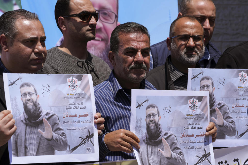 Palestinians hold pictures of Khader Adnan, a leader in the militant Islamic Jihad group, who died in Israeli prison after a nearly three-month hunger strike, during a sit-in in front of the International Committee of the Red Cross office, in Gaza City, Tuesday, May 2, 2023. Arabic on pictures read " Fatah mourns the martyr, prisoner and leader Khader Adnan, was killed due to deliberate medical negligence. " Adnan had begun staging protracted hunger strikes more than a decade ago, introducing a new form of protests against Israel's mass detentions of Palestinians without charges or trials. On Tuesday, the 45-year-old became the first long-term hunger striker to die in Israeli custody. (AP Photo/Adel Hana)