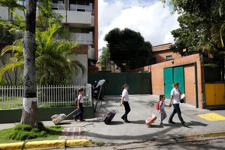 Caribay Valenzuela (R), walks with her daughters (L-R) Carlota, Eloisa and Carmen, after picking them up on the school on a day of protests in Caracas, Venezuela June 19, 2017. REUTERS/Carlos Garcia Rawlins